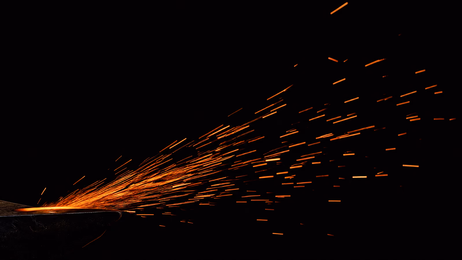 A shower of orange sparks thrown across a near-black frame.